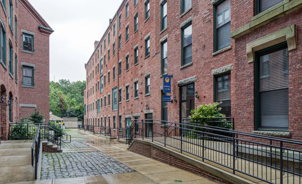 a large red brick building with a sidewalk in front of it